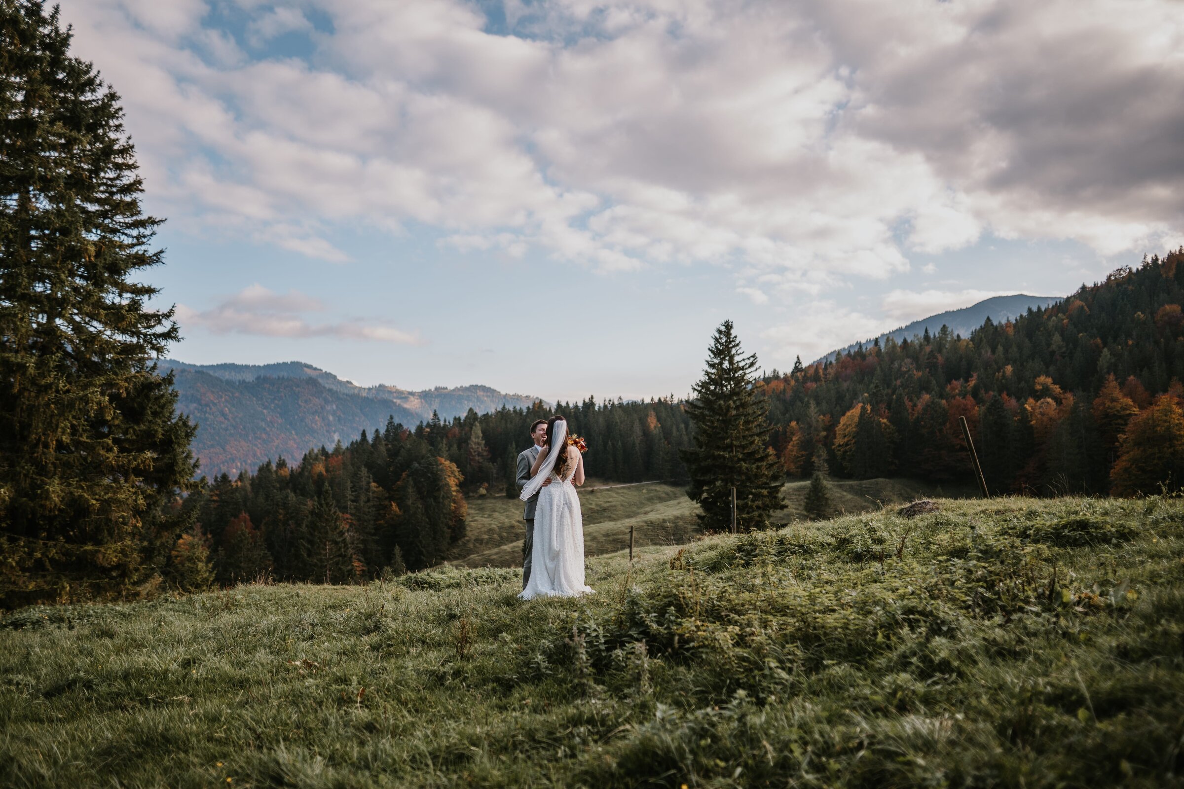 Brautpaar auf Almwiese in den bayerischen Alpen bei natürlichem Licht