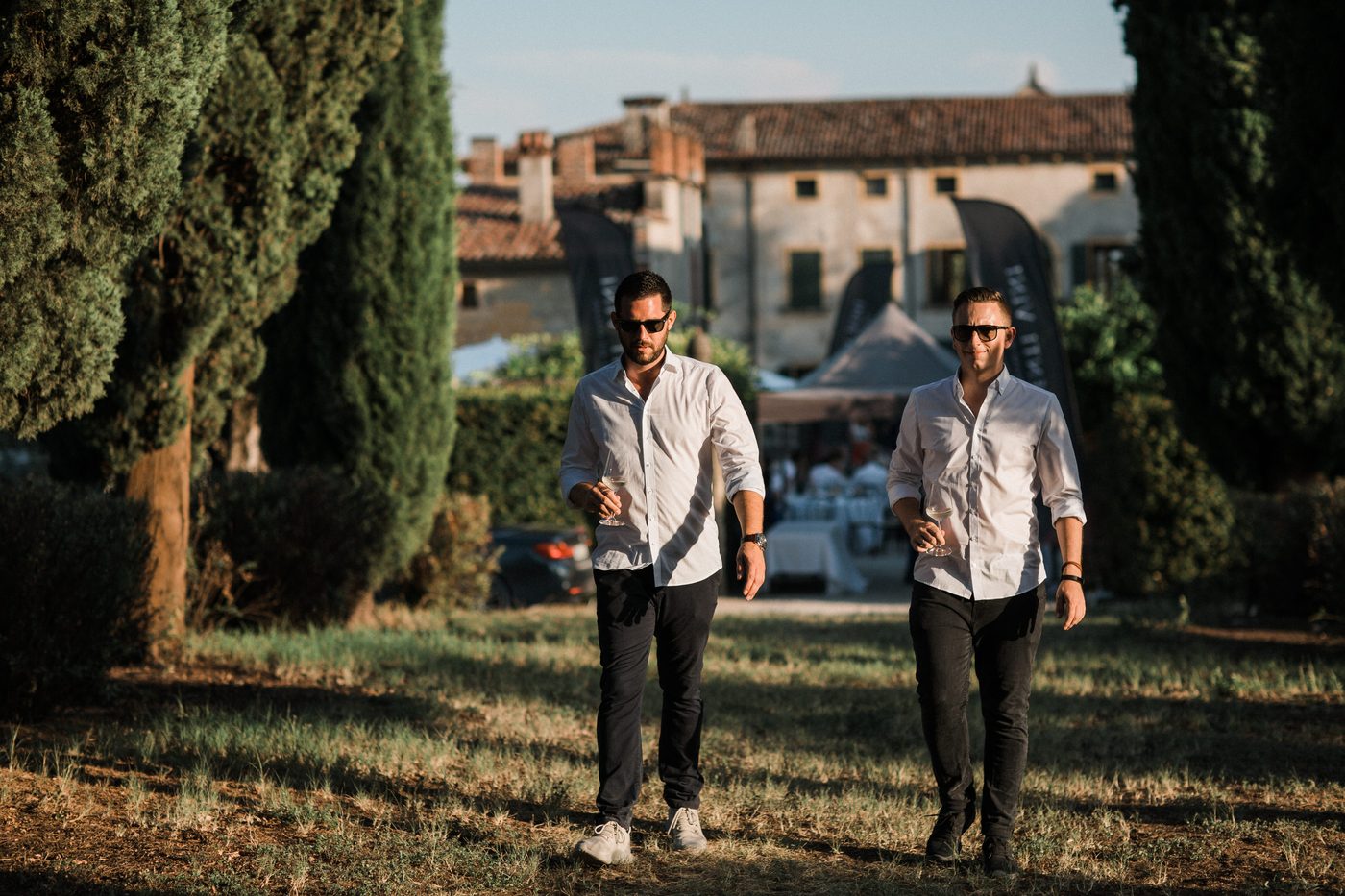 Zwei Gaeste spazieren durch die Zypressenallee beim Senti Vini Sommerfest 2017 in Italien