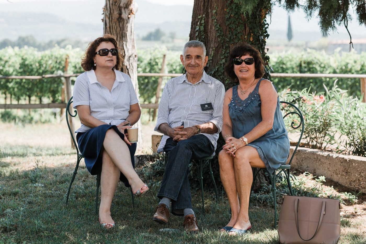 Gaeste des Senti Vini Sommerfests 2017 sitzen vor den Weinreben nahe Verona
