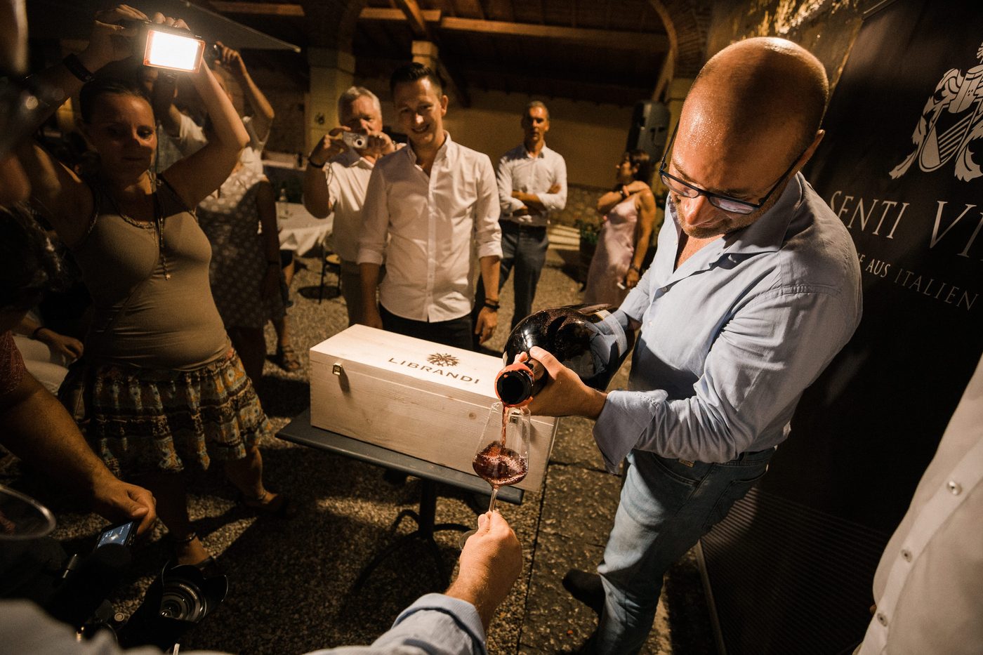 Weinpraesentation mit Rotwein am Abend beim Senti Vini Sommerfest 2017 nahe Verona