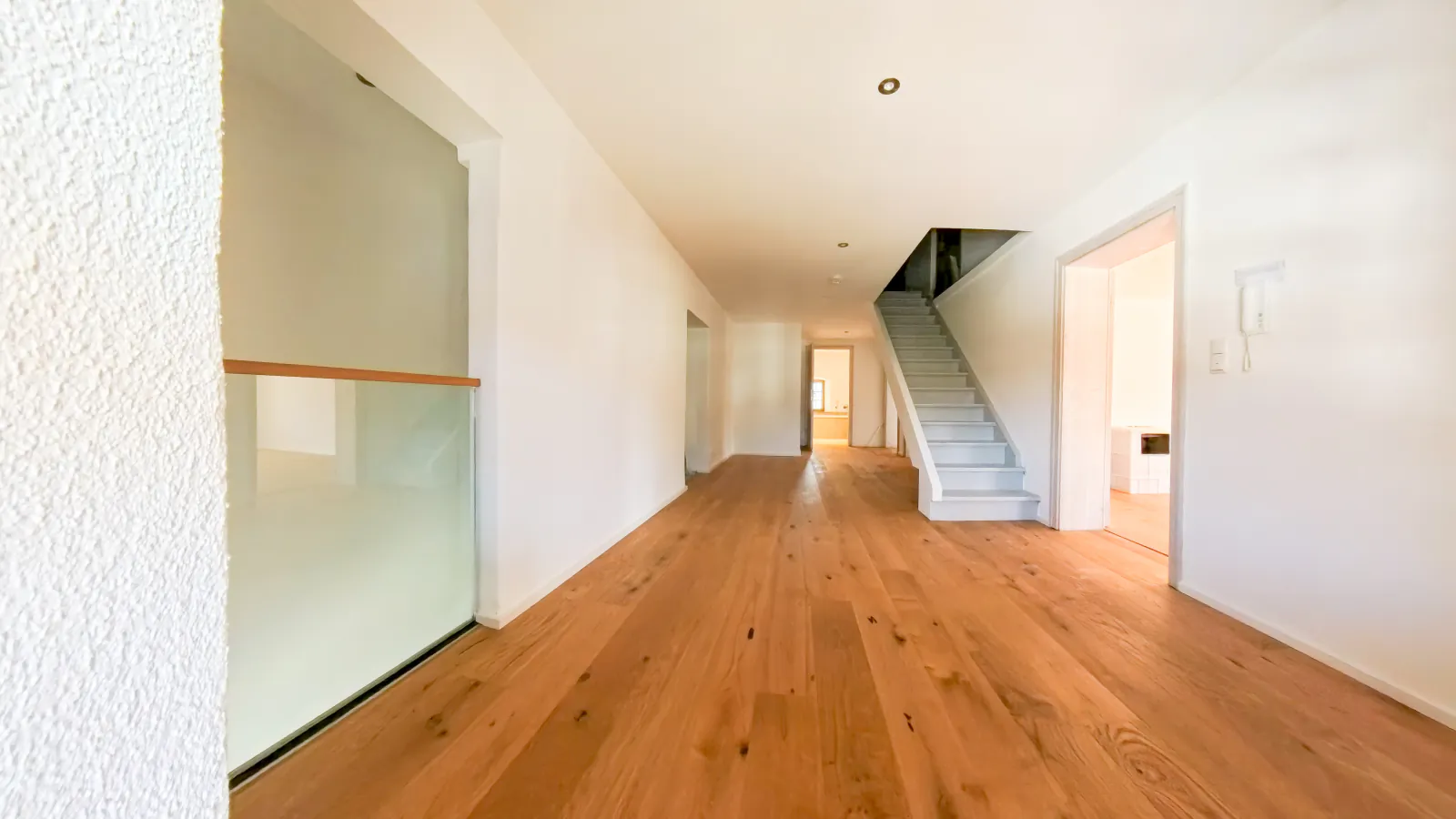 Flur mit Eichenparkett, Glasbrüstung und Treppe