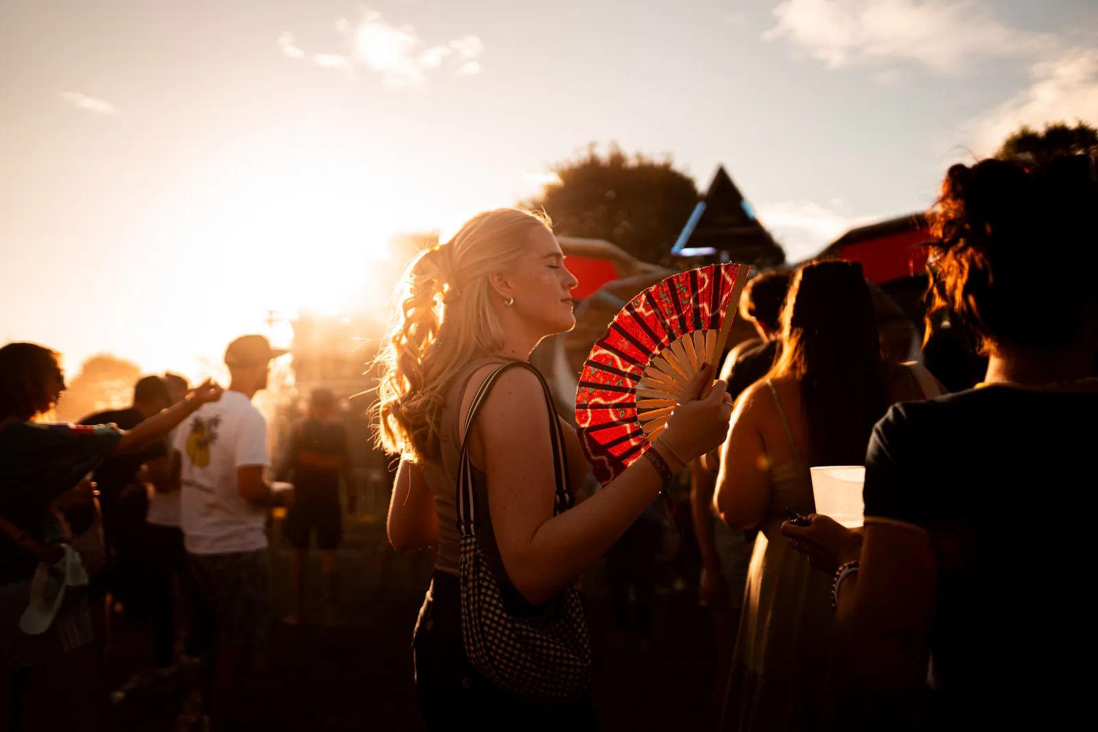 Besucherin tanzt mit Fächer im Gegenlicht, Zauberwald Festival 2026