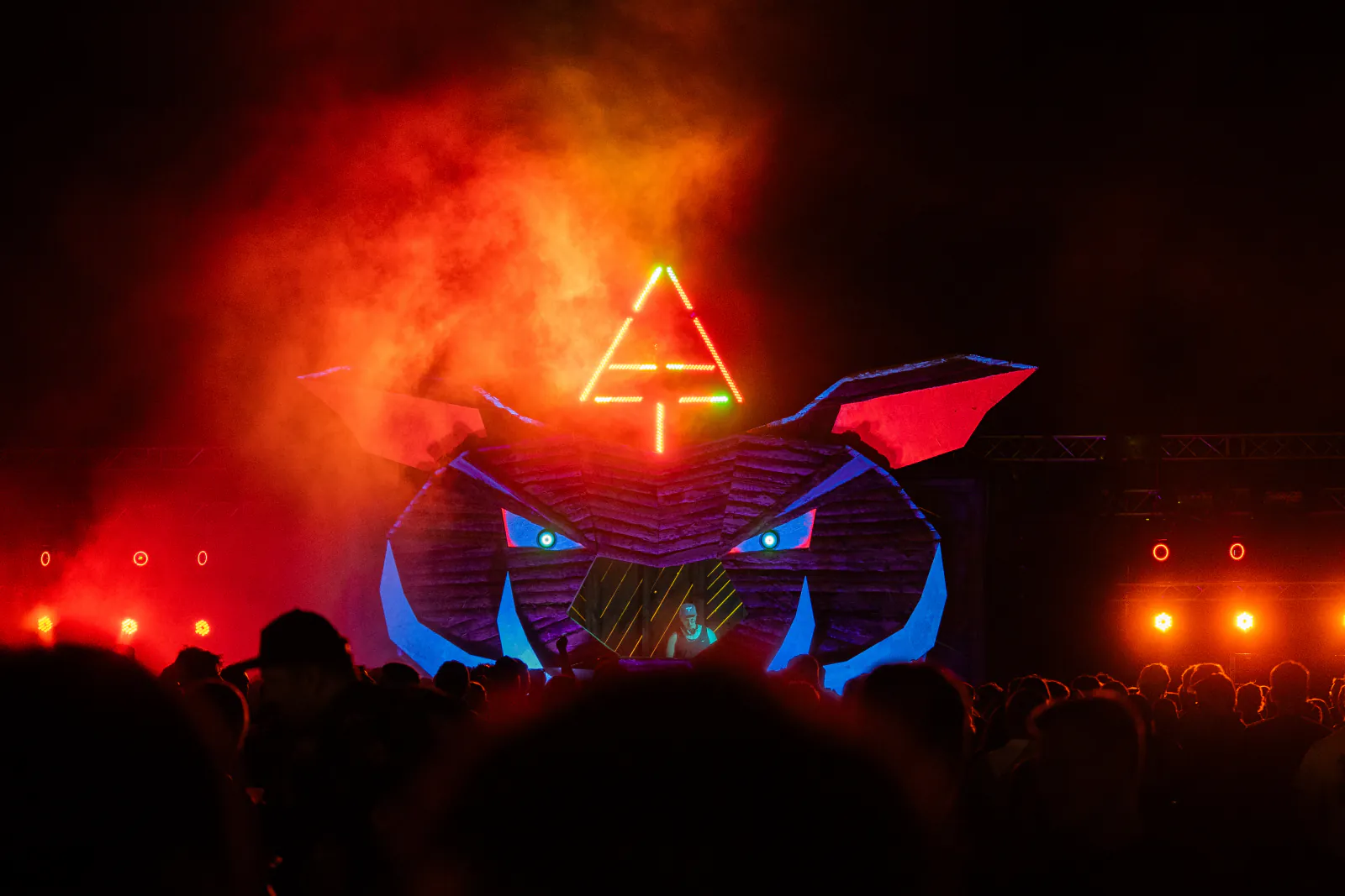 Hauptbühne des Zauberwald Festival 2026 bei Nacht mit leuchtendem Tierkopf, Neonsymbol und rotem Nebel