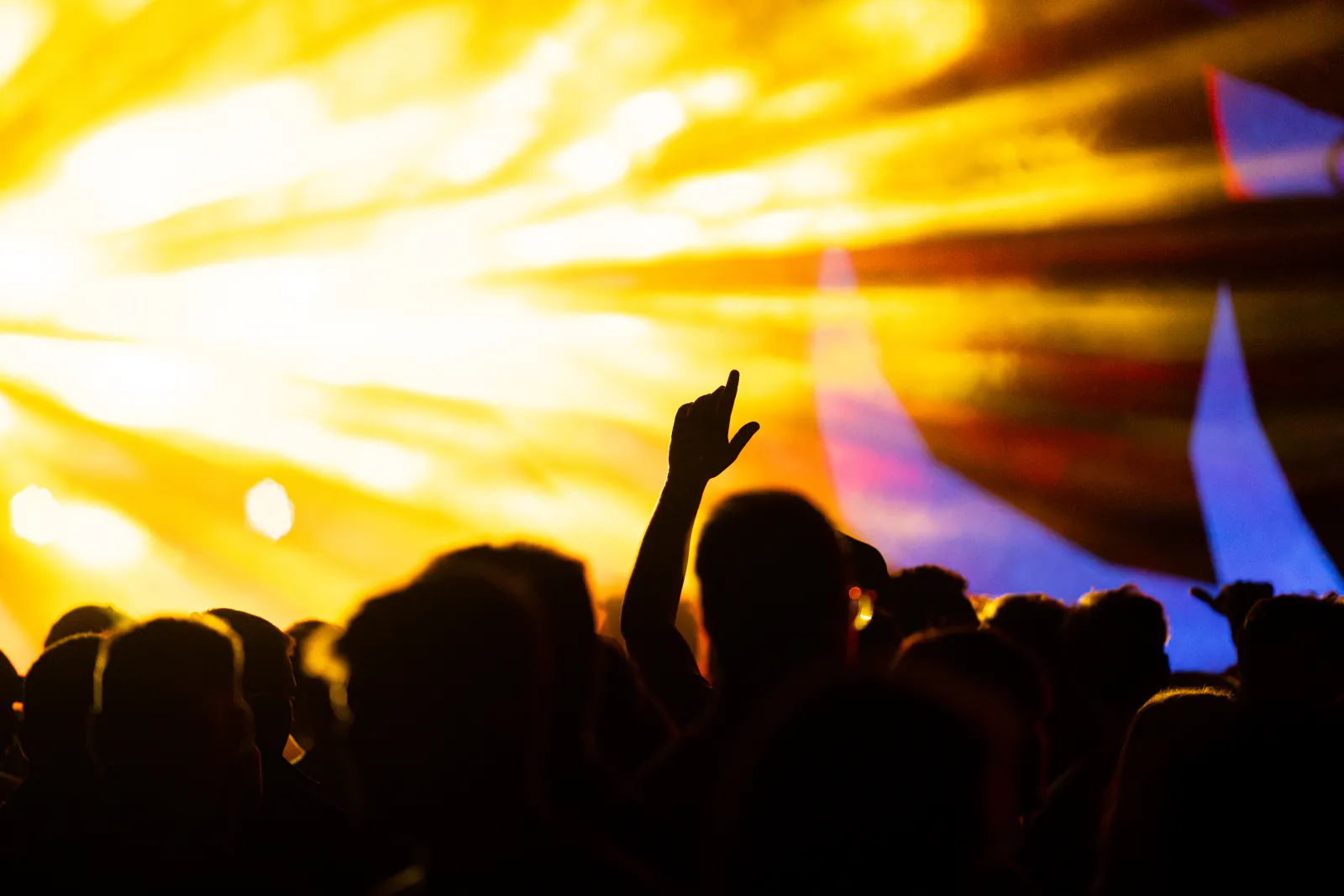 Jubelnde Crowd unter Lichtstrahlen bei Nacht