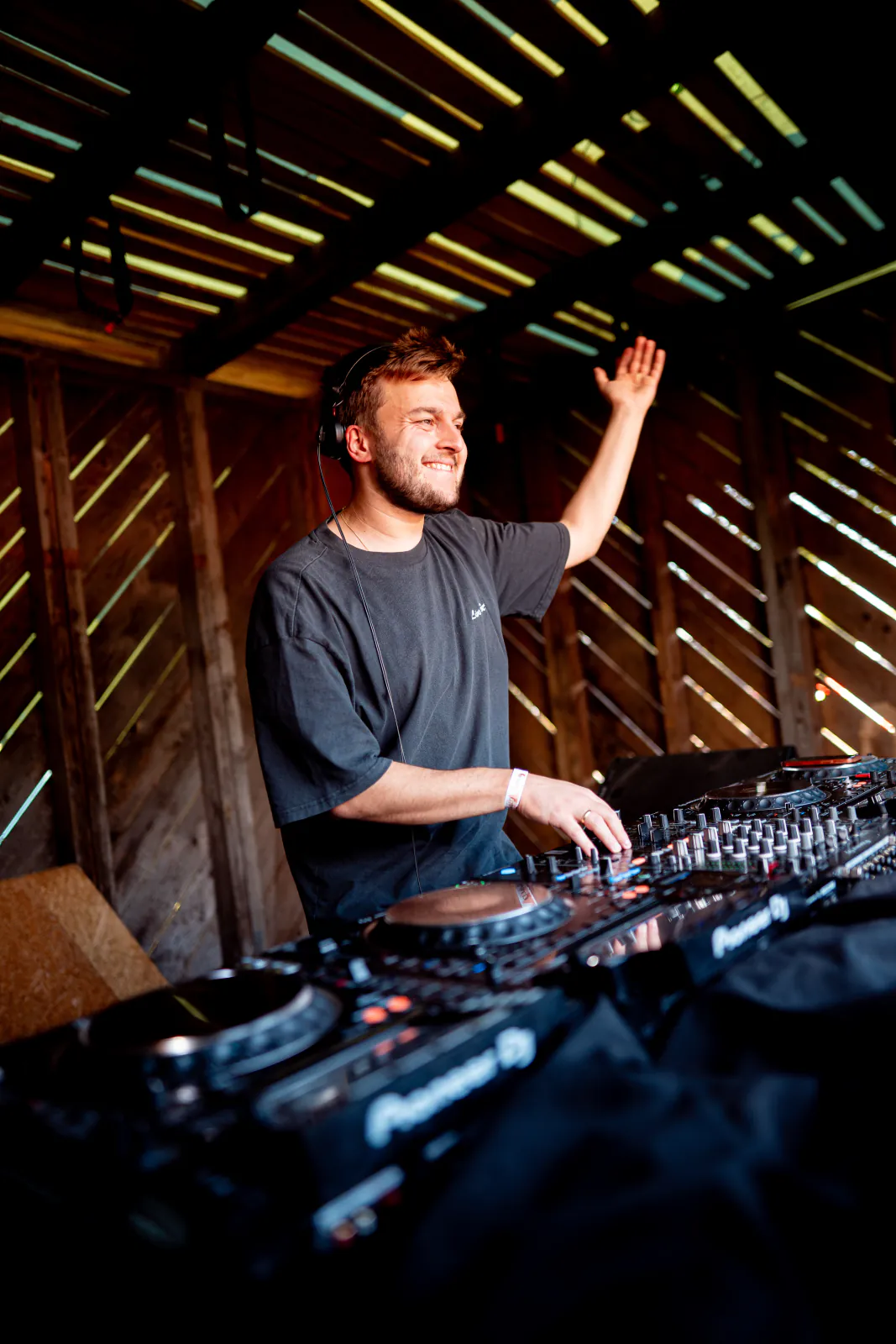 DJ an den Pioneer-Decks im hölzernen DJ-Pult beim Zauberwald Festival 2026