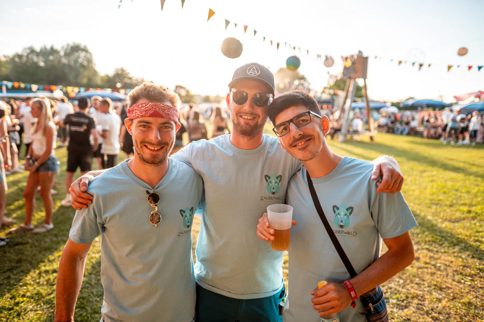 Freunde posieren für ein Gruppenfoto auf der Festivalwiese
