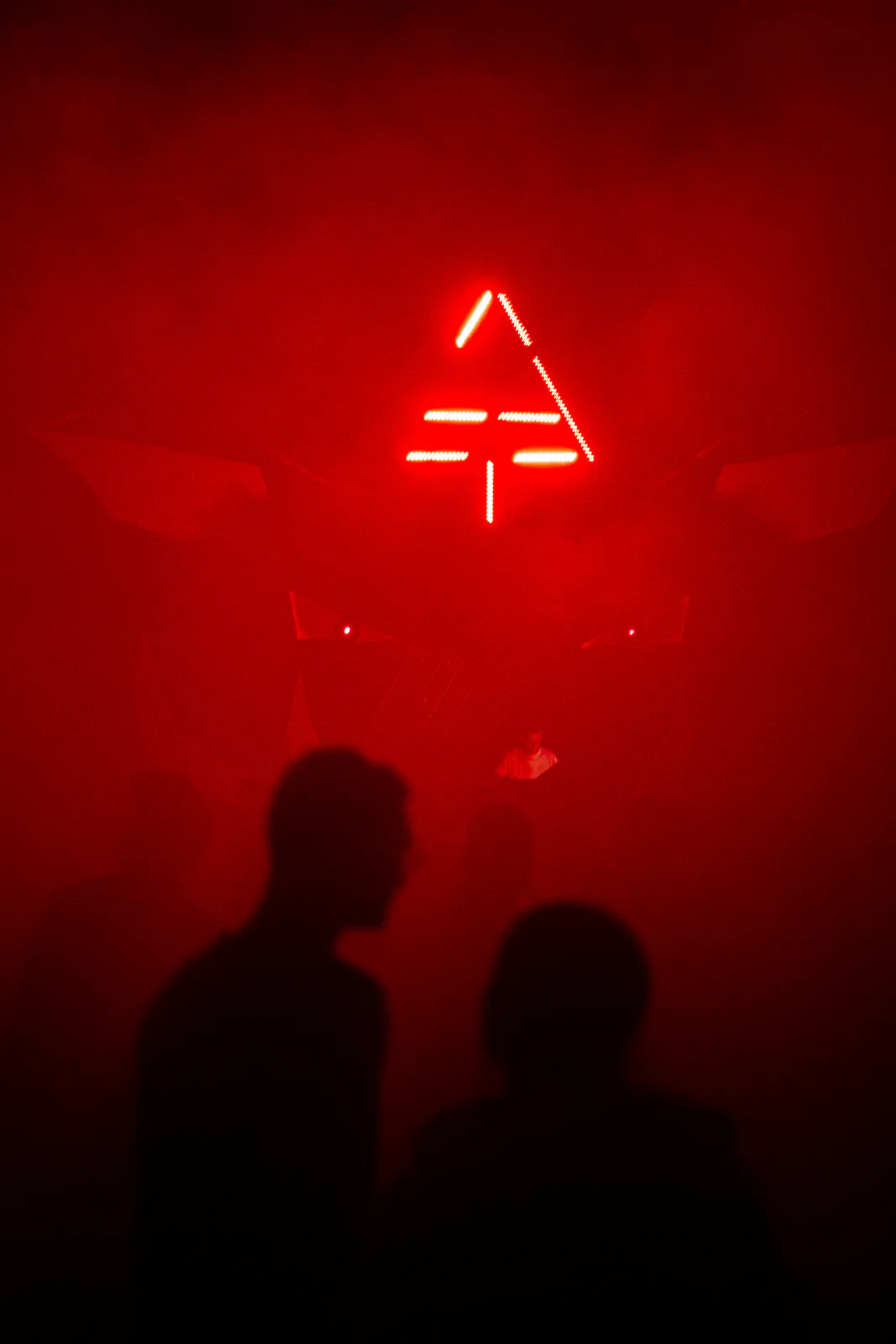 Rotes Neonsymbol des Festivals über Silhouetten