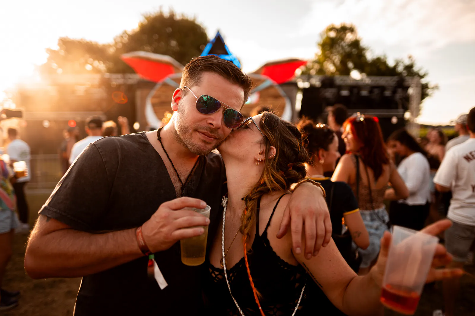 Paar mit Sonnenbrille feiert im Gegenlicht