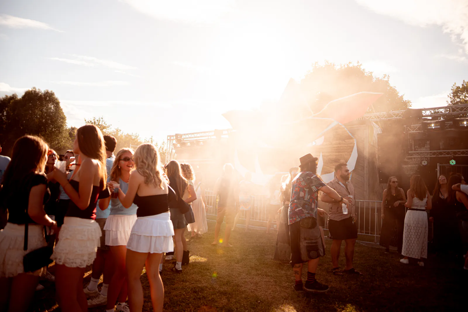 Tanzende Gäste im Sonnenlicht und aufgewirbeltem Staub beim Zauberwald Festival 2026