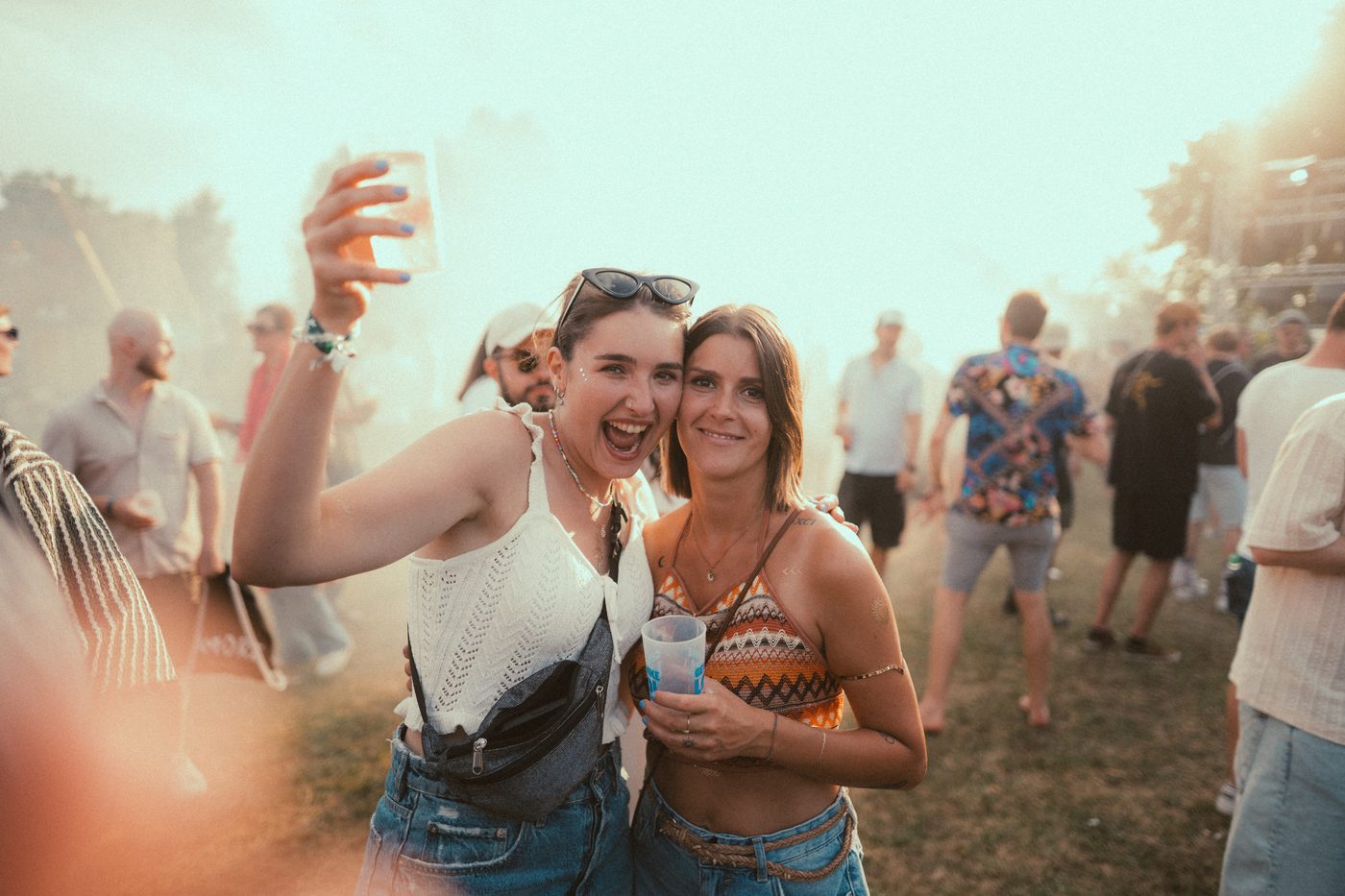 Zwei Festivalbesucherinnen jubeln im Sonnenlicht beim Zauberwald Festival 2025 Hohenthann