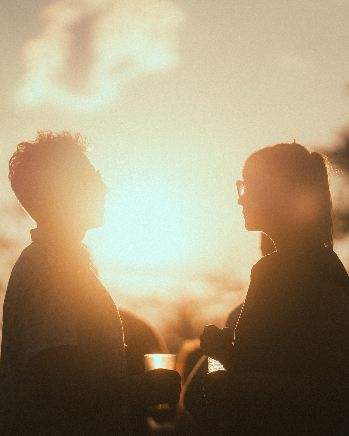Silhouetten zweier Besucher im Gegenlicht beim Sonnenuntergang am Zauberwald Festival 2025