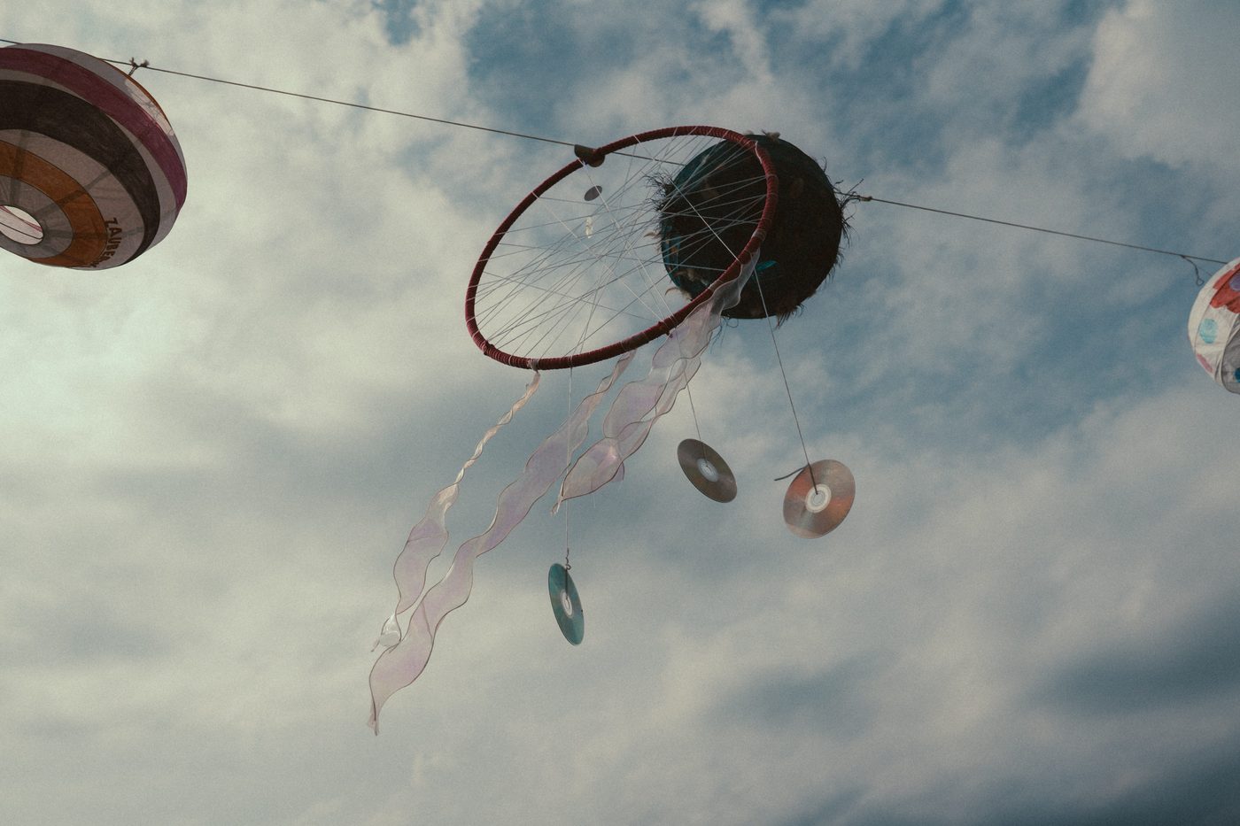 Traumfaenger und CD-Dekoration vor bewolktem Himmel beim Zauberwald Festival 2025 Hohenthann